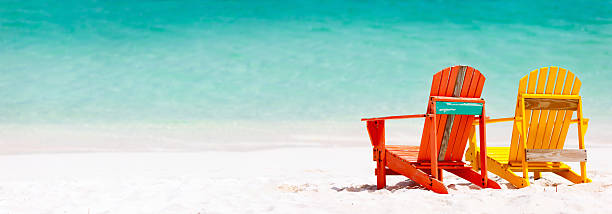 istock Red and yellow Adirondack chairs, on a Caribbean beach 472654992