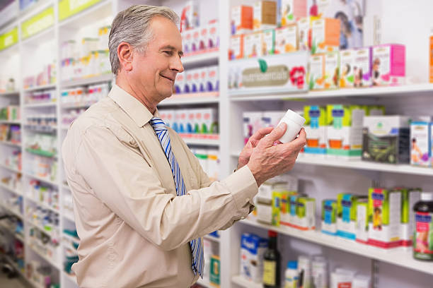 istock Smiling customer looking at medicine 472657760