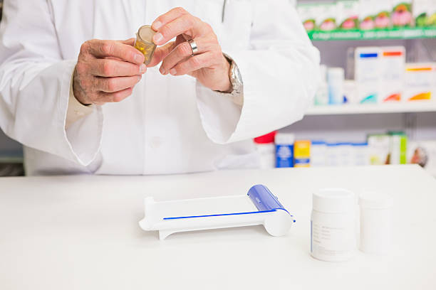 istock Pharmacist holding jar of medicine 472658088