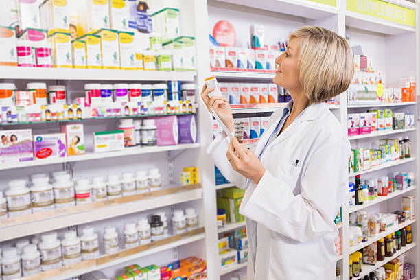 istock Smiling pharmacist holding prescription and medicine 472658842