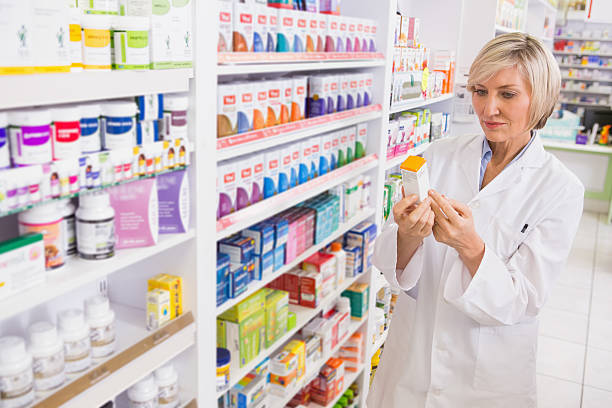 istock Smiling pharmacist looking at medicine 472658850