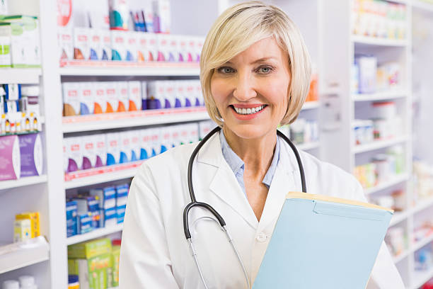 istock Smiling doctor with stethoscope holding files 472659006