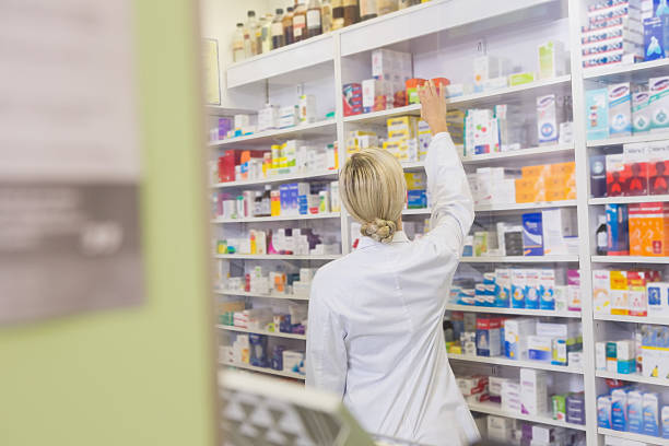istock Rear view of student taking medicine from shelf 472659622