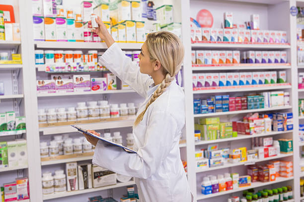 istock A female junior pharmacist taking medicine from a shelf 472661082