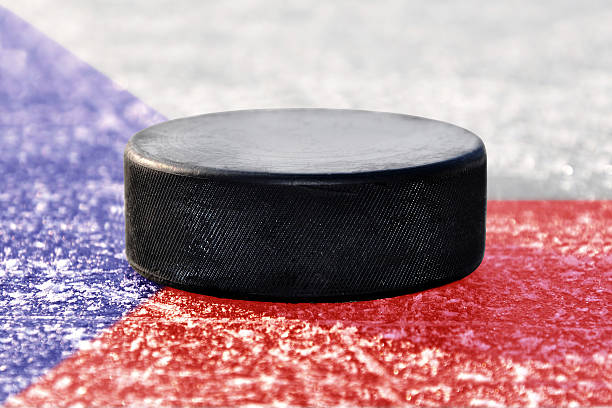 istock Black hockey puck on ice rink 472662362