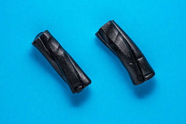 Two liquorice candies on blue turquoise paper