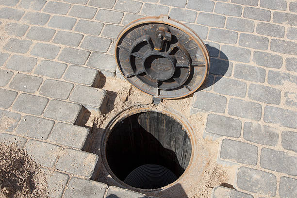 istock Sewer hole in a brick road 472665078