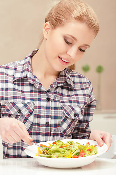 istock Young woman cooks salad 472665558