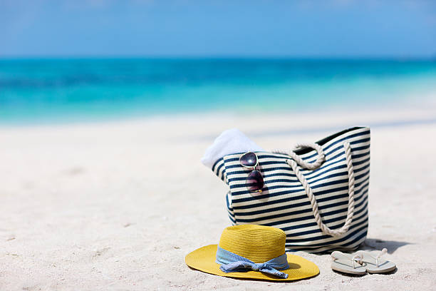 istock Beach bag, hat and flip flops on the beach with ocean 472667806