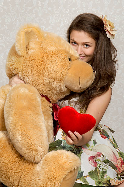 istock Girl with stuffed heart and bear 472670268