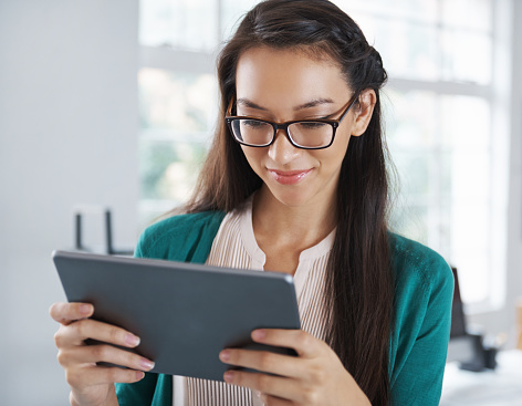 Shot of an attractive young woman using a digital tablet while standing in an officehttp://195.154.178.81/DATA/i_collage/pu/shoots/795703.jpg