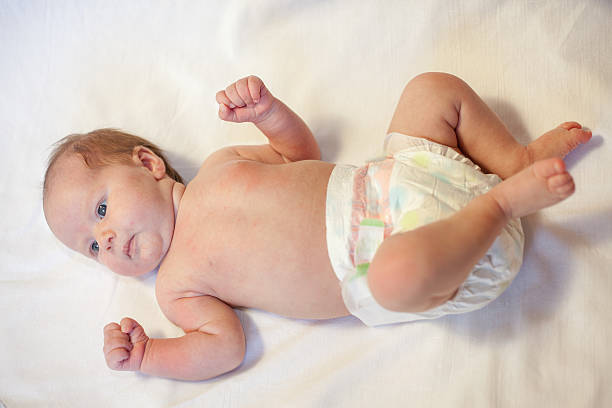 istock Newborn baby dressed in diaper, lying on a white background 472678500