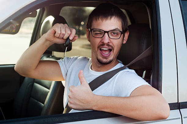 Young male caucasian driver is holding new car key stock photo