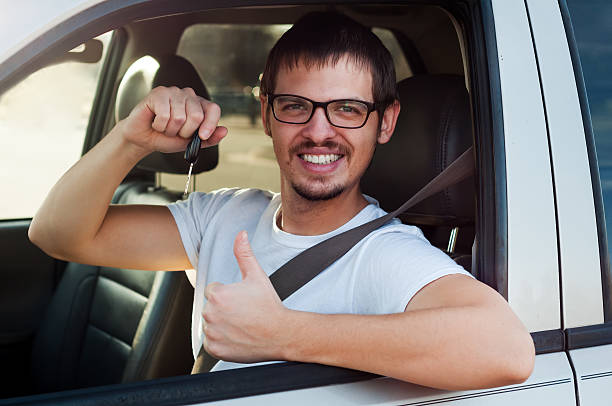 Young male european driver is holding new car key stock photo