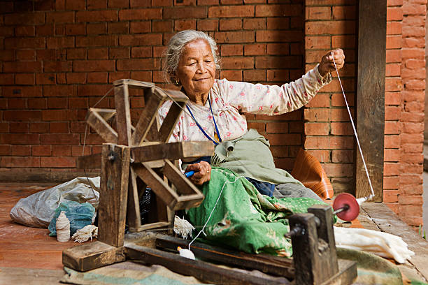 istock Nepali woman spinning the wool. Bhaktapur 472683888