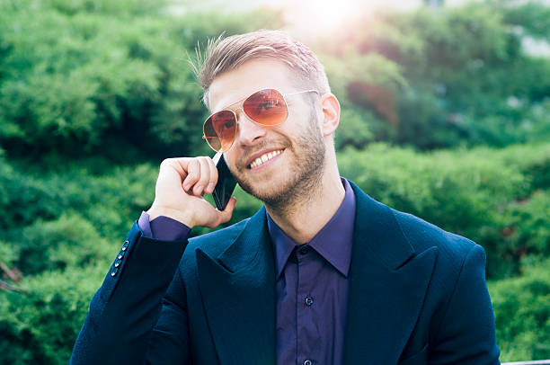 istock Smiling businessman uses smartphone 472689008