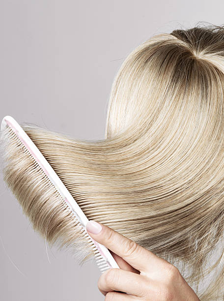 istock Blond hairpiece brushed by a woman 472691998