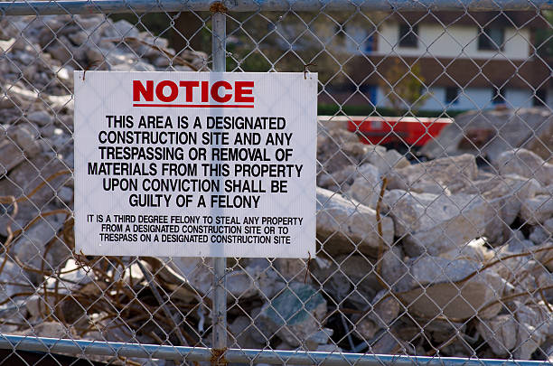 Construction site no trespassing sign posted on fence stock photo