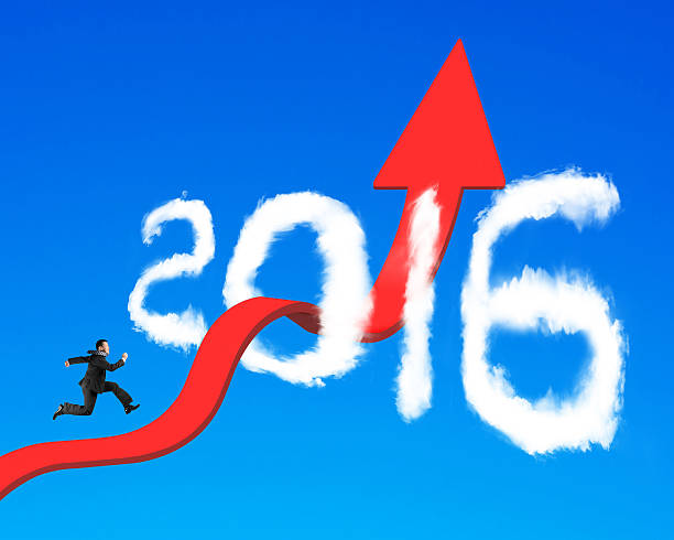 istock Businessman running on arrow upward trend line through 2016 clou 472693696