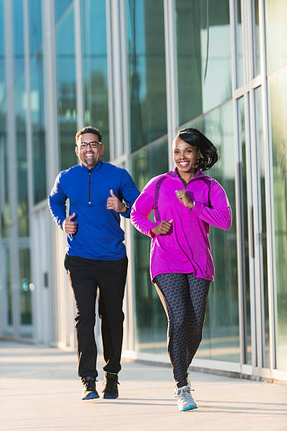 istock Mature black couple jogging on city sidewalk 472694090