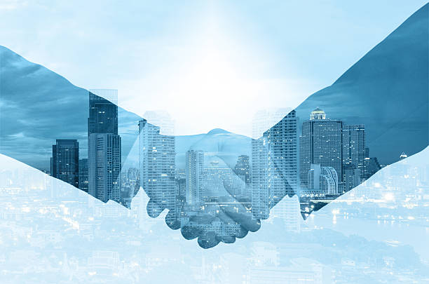 istock double exposure handshake between businessman on a city background 472695476