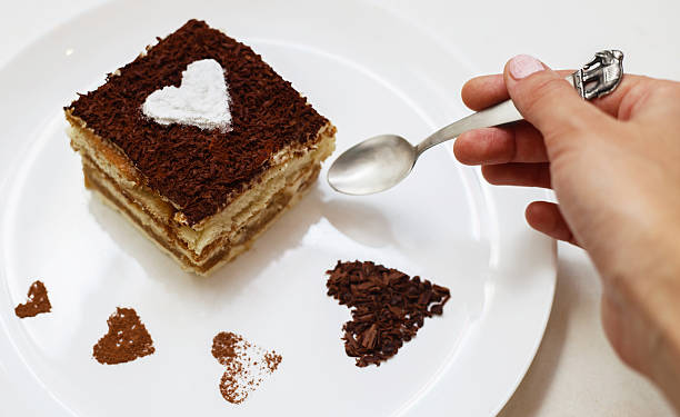 Girl eating tiramisu cake with heart stock photo