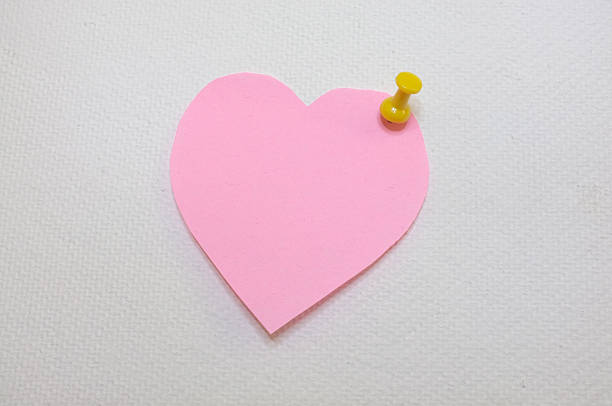 istock Note paper in heart shape with yellow pin 472703030