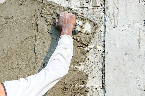 istock plasterer concrete worker at wall of house construction 472703288