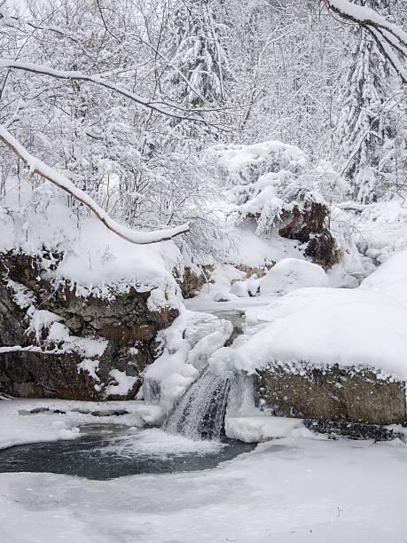 istock Small waterfall in mountain stream in winter 472705816