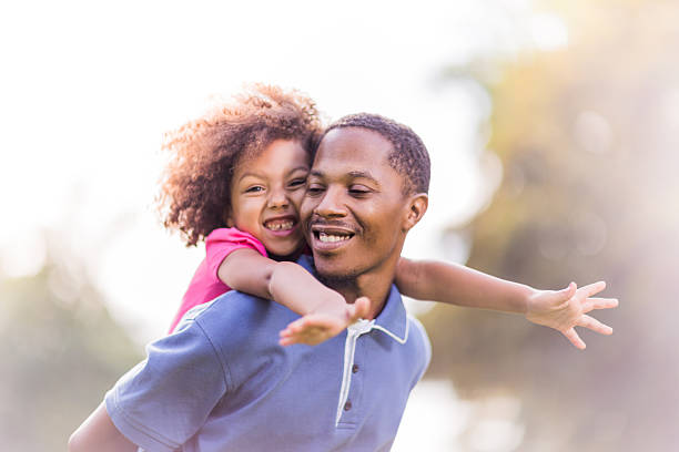 istock Father giving daughter a piggyback ride on a sunny day 472706988