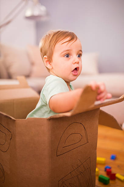 istock Baby boy playing in a cardboard box 472707838