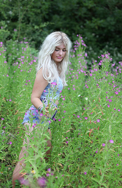 istock Beautiful young woman in long grass 472708764