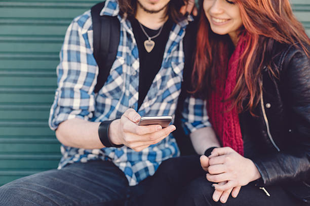 istock Young couple text messaging on smartphone 472710750