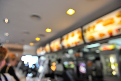 Blurred background: fast-food restaurant interior.