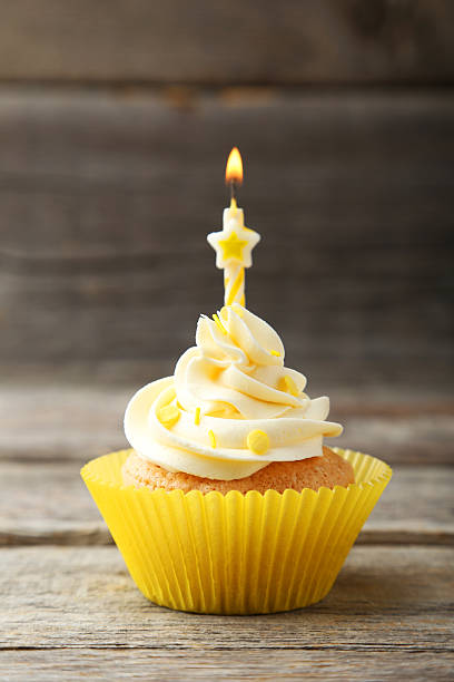 istock Tasty cupcake with candle on grey wooden background 472713440