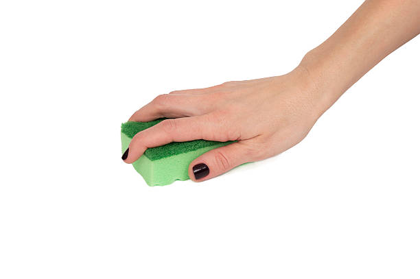 istock woman hand using green sponge isolated over white 472716820