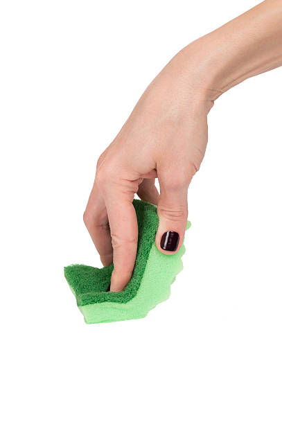 istock woman hand using green sponge isolated over white 472716844