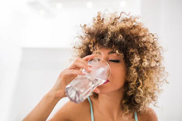 Young African American woman drinking water.