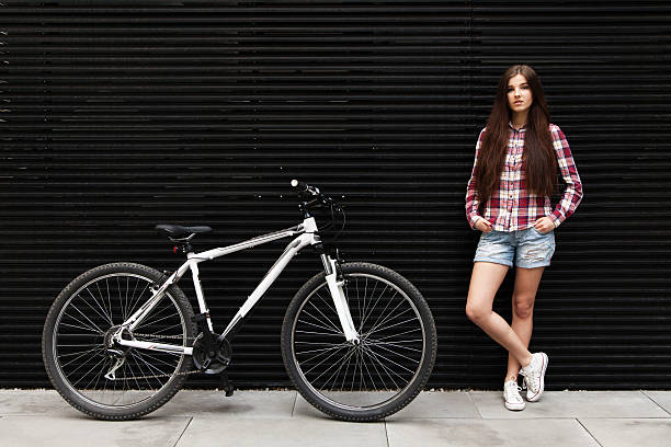 istock Young beautiful woman on a bicycle 472718096