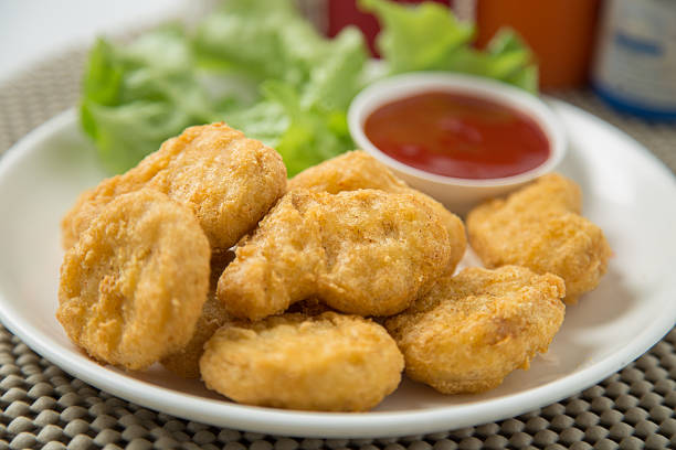 istock pile of chicken nuggets on white plate with sauce 472718176