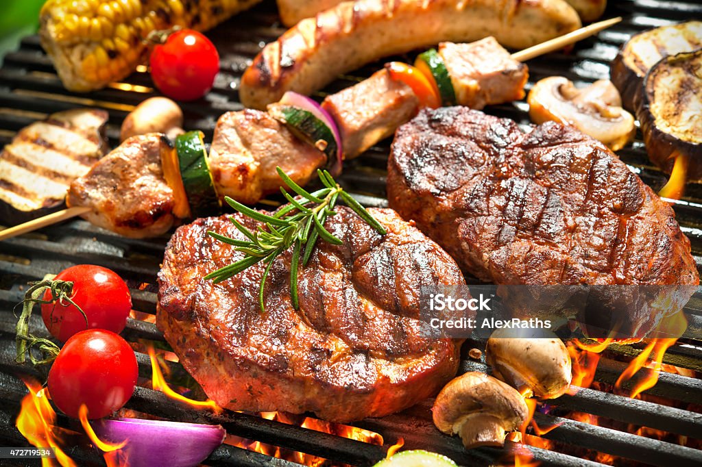 Grill Assorted delicious grilled meat with vegetable over the coals on a barbecue Barbecue Grill Stock Photo