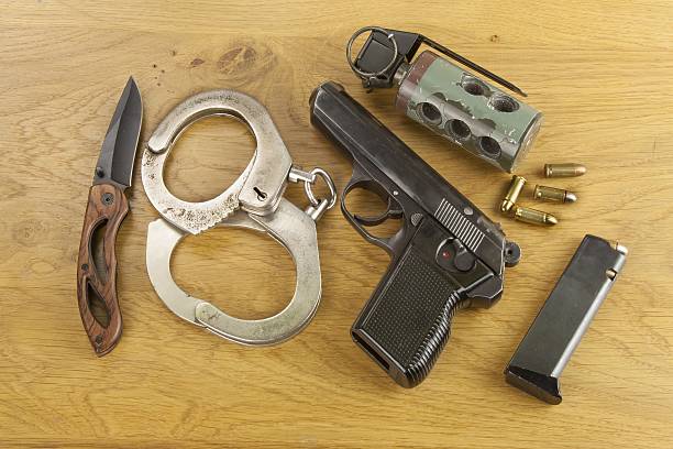 istock firearm lying on the table, metal police handcuffs 472730656