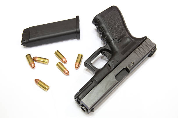 istock Closeup Bullets and Gun on white background 472730740