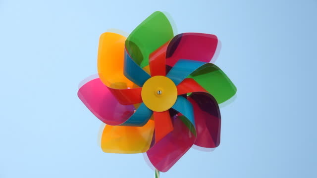 Colorful paper windmill spinning in blue sky
