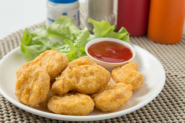 istock pile of chicken nuggets on white plate with sauce 472778488
