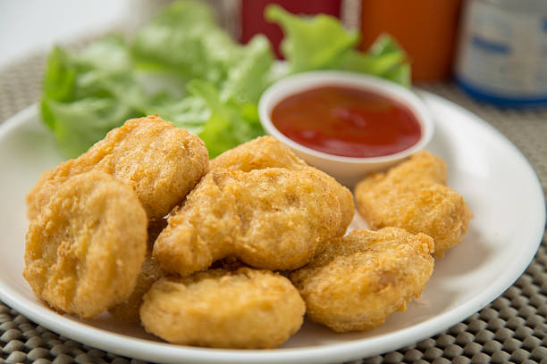 istock pile of chicken nuggets on white plate with sauce 472778494