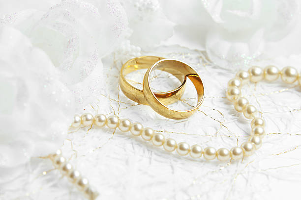 istock Two golden wedding rings with seamless flower decorations 472778602