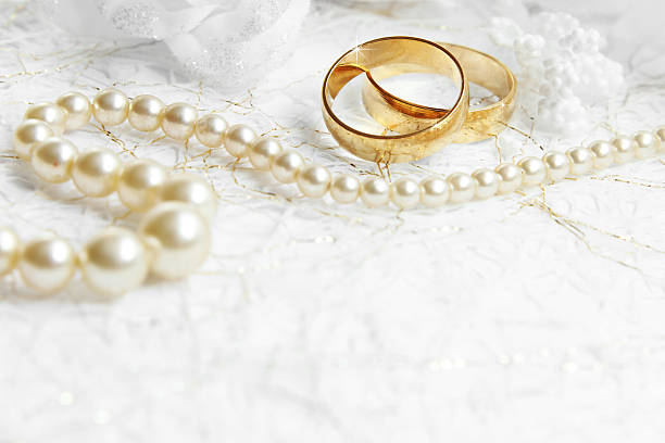 istock Two golden wedding rings with seamless flower decorations 472778608