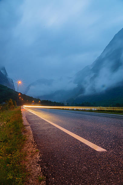 istock Long exposure car light and wet asphalt road 472783908