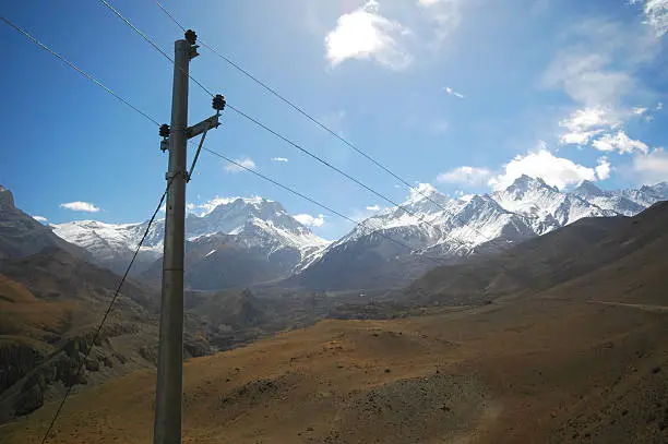 Electrical posts with power line cables connecting remote villages in the Annapurna circuit to power and communication